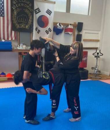 Grandmaster demonstrating her trademark scorpion kick with students.